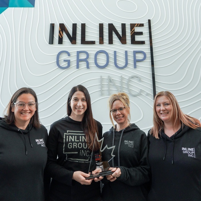 Inline Group staff holding an award